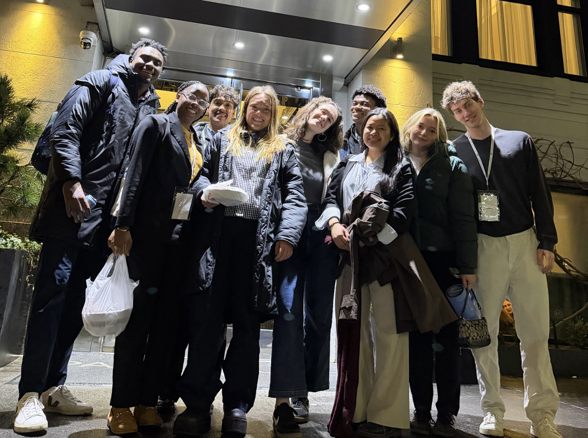 Students pose for a photo in front of Park South Hotel, owned by Thomas C. Glassie '87. 