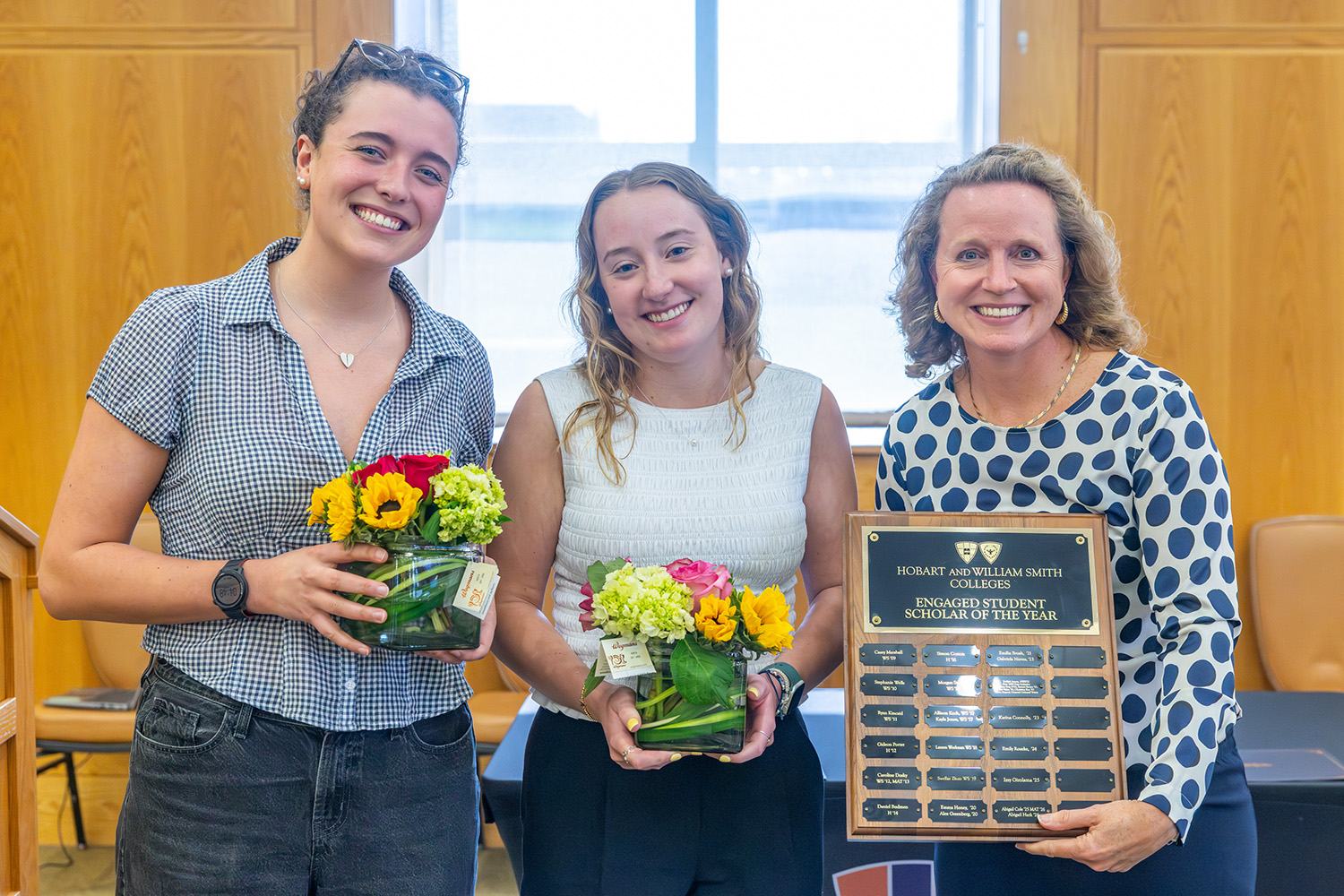 flowers presents two students with plaque 