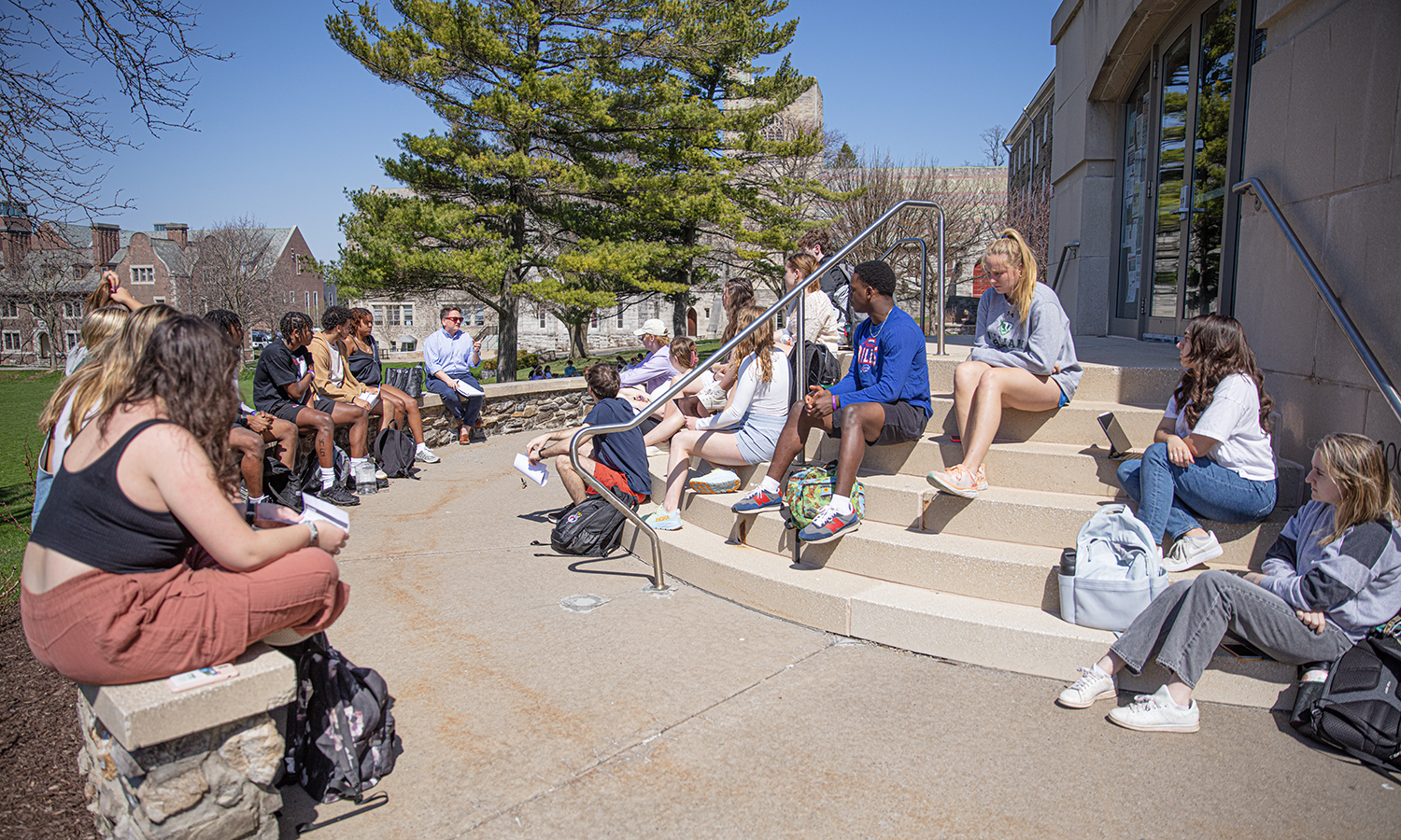 Taking advantage of the warm weather, Director of Teacher Education Program and Secondary Education Andie Huskie holds class on the steps of the Salisbury Center at Trinity Hall.
