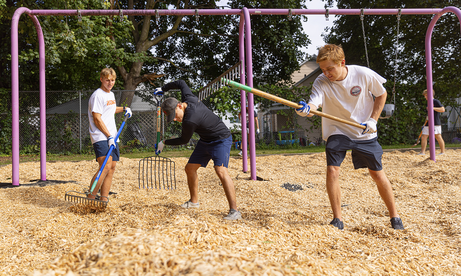 Students spread wood chips at Richards Park playground during community service activities.