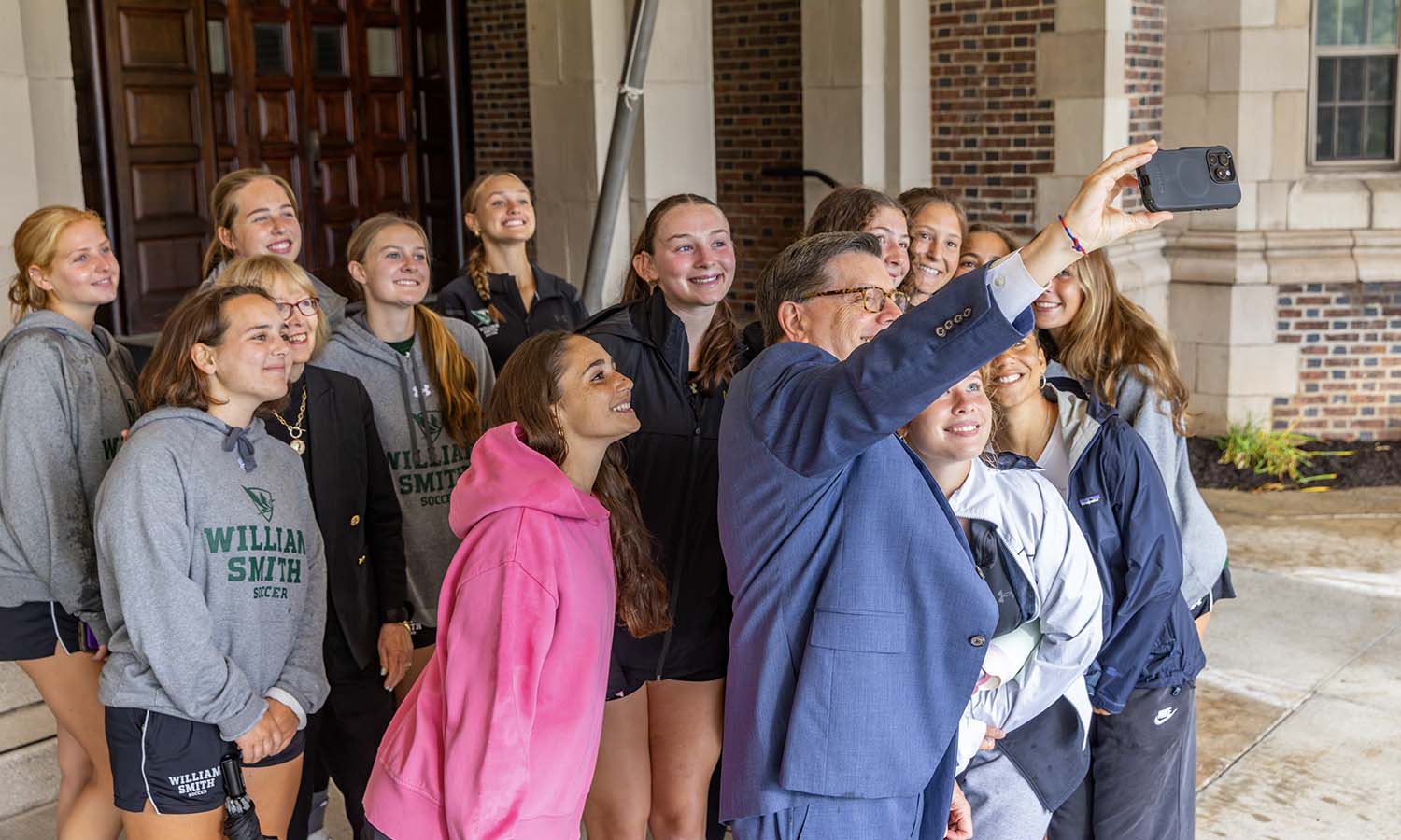 President Mark D. Gearan and Mary Herlihy Gearan take a selfie with first-years on the William Smith soccer team. 