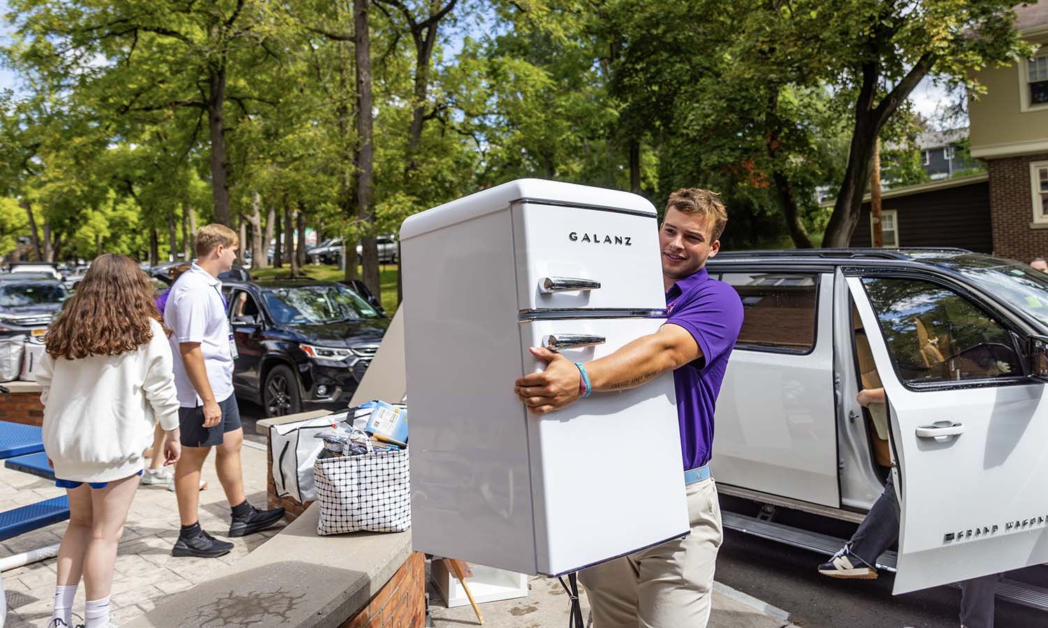 Michael Schafer ’26 helps a student with their mini-fridge. The Hobart lacrosse team pitched in during move-in. 