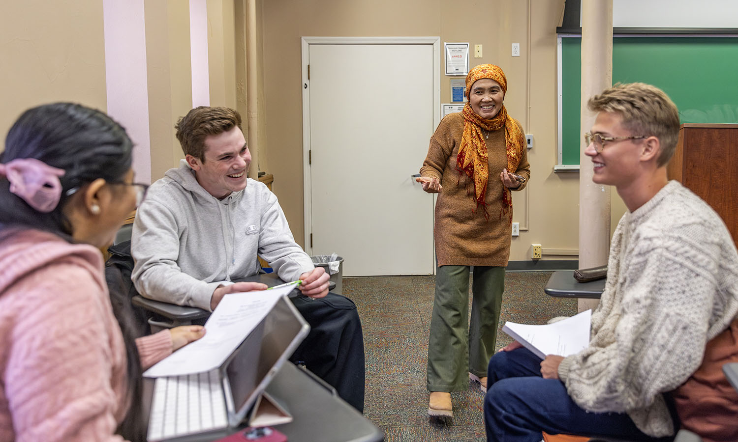 Professor of Religious Studies Etin Anwar shares a laugh with Christina Mohonta ‘27, Christian Donnelly ‘25 and Alberto Garcia De La Puente Stanley ’25 during “Sustainability, Fashion & Justice.” 