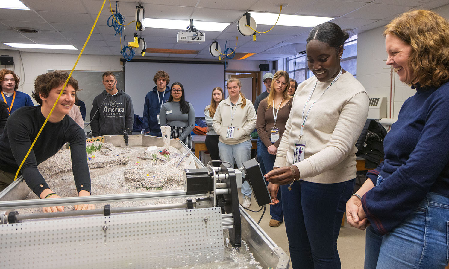During an Admitted Student Day open house, students and their families examine a stream table with Associate Professors of Geoscience Tara Curtin and David Finkelstein. 