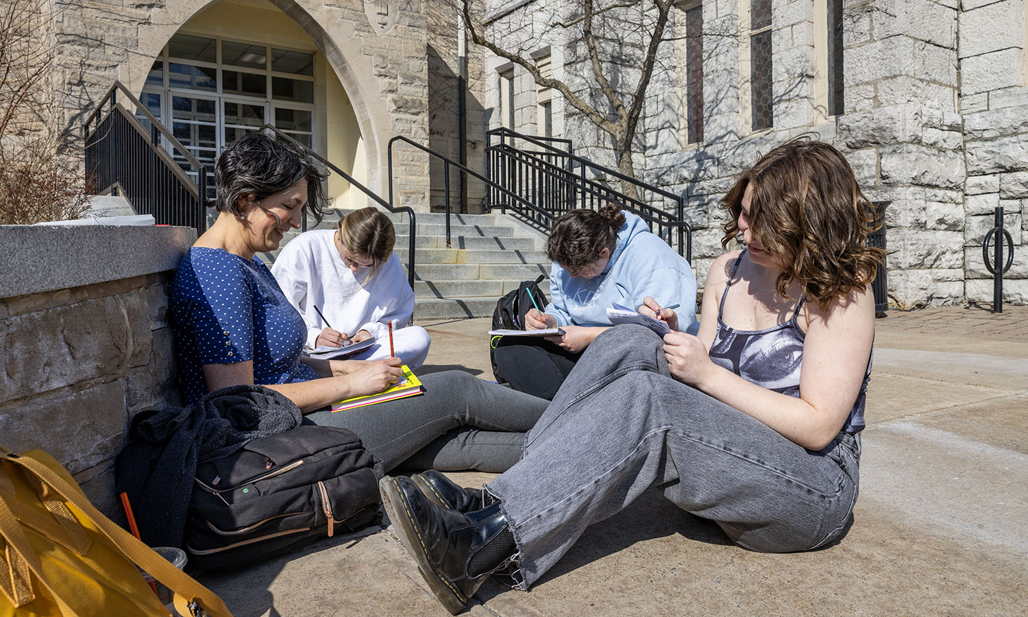 Outside Demarest Hall, Michelle Martin-Baron, Associate Professor of Gender, Sexuality and Intersectional Justice, works with students to make zines during a capstone class. 