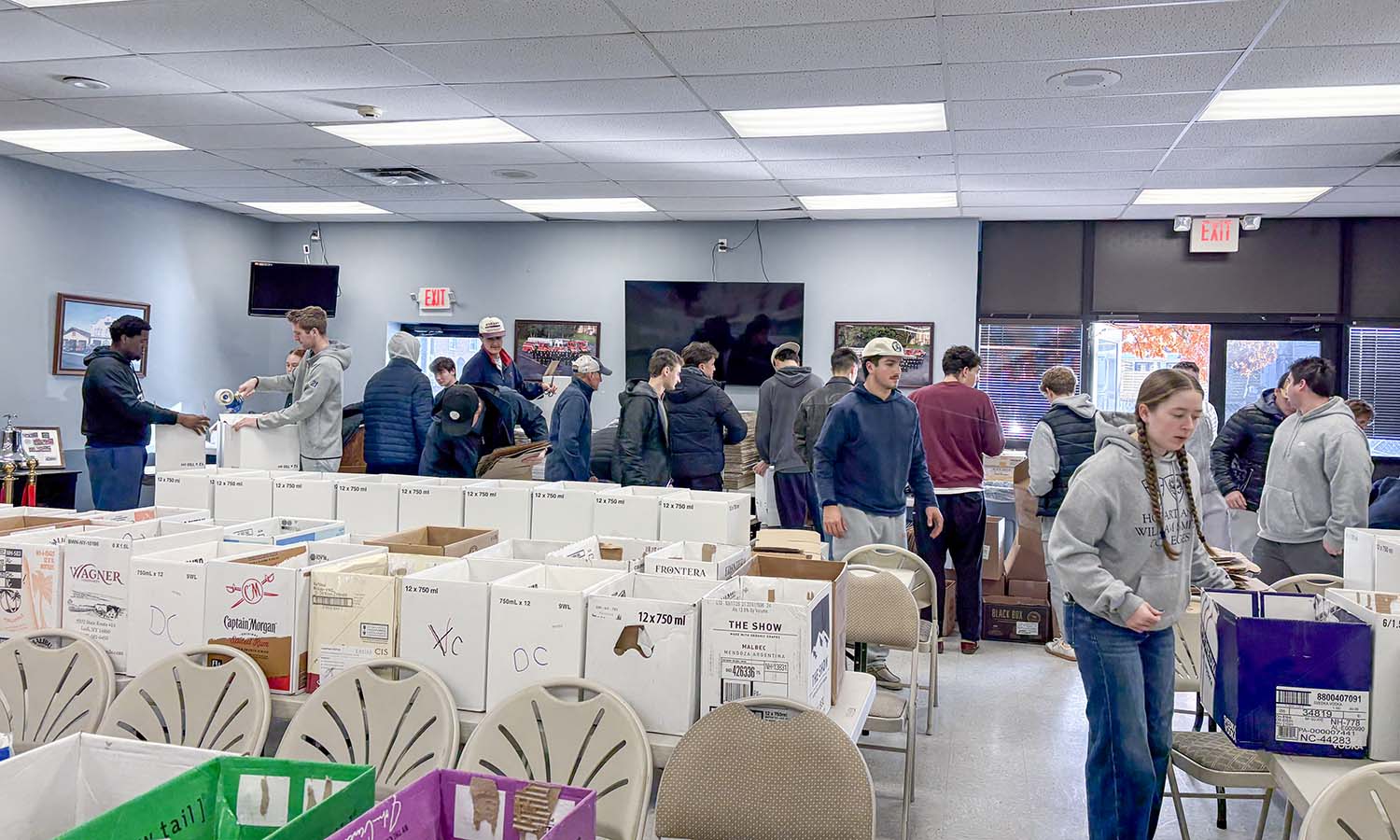 At Geneva’s Hydrant Hose Fire Department, students help move newly donated food for the Lady of Peace Parish after a fire destroyed their food supply intended for families on Thanksgiving. 
