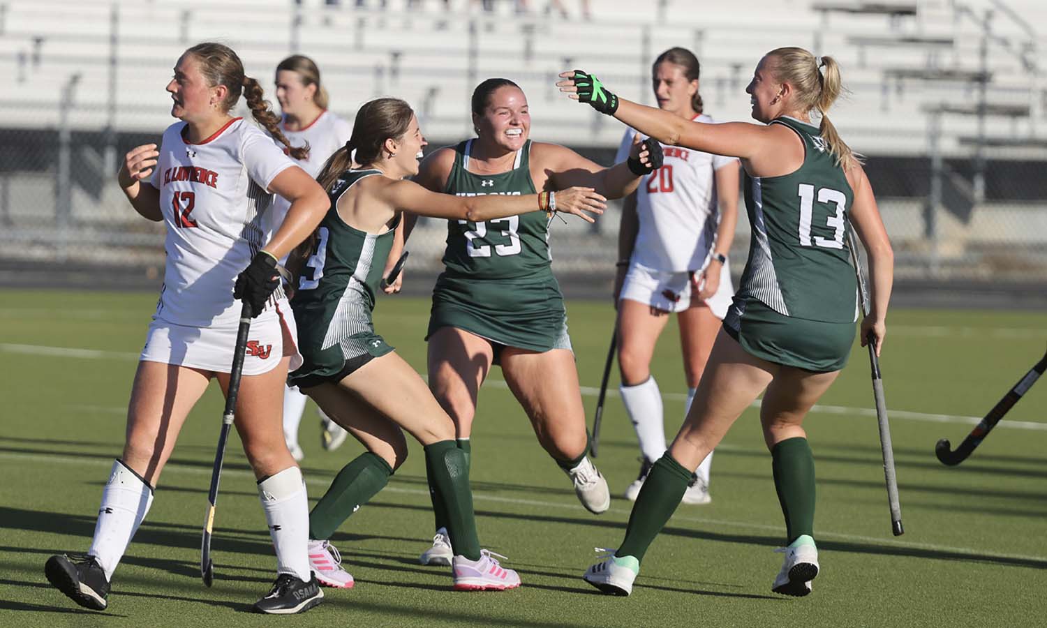 Ana Dios Vidal ’28 and Caroline Kogut ’28 celebrate with Hadley Harbert ’28 after Harbert scored the go-ahead goal during William Smith field hockey’s 3-1 victory over St. Lawrence 