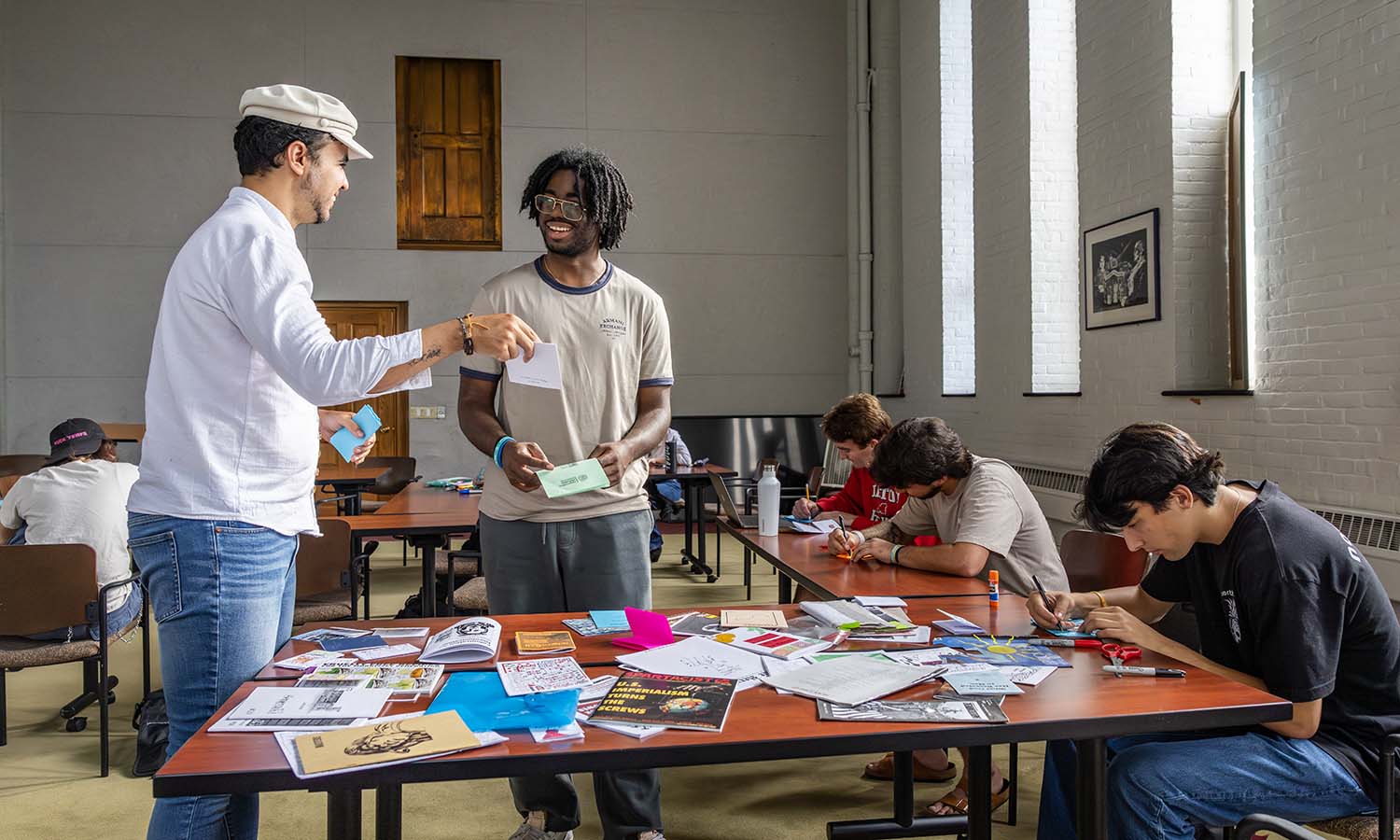 Fisher Center Post-Doctoral Fellow André de Oliveira Nascimento helps Robert Roseboro ’26 during “The Real Punk Rock” zine-making workshop. 