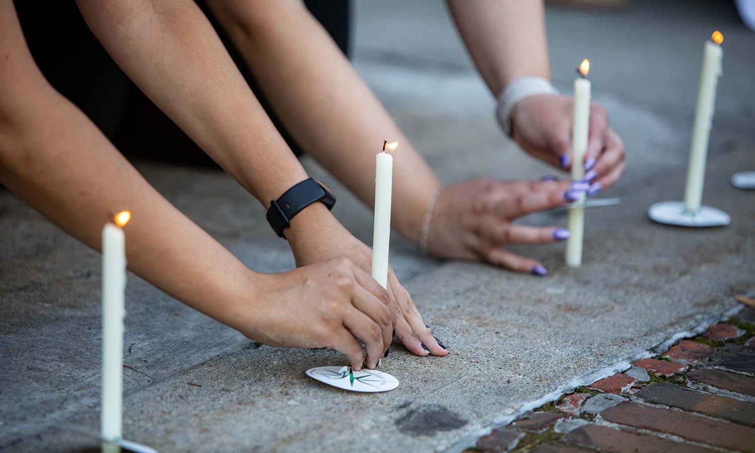 Students, faculty and staff place candles outside Coxe Hall during the Take Back the Night event on Tuesday. 