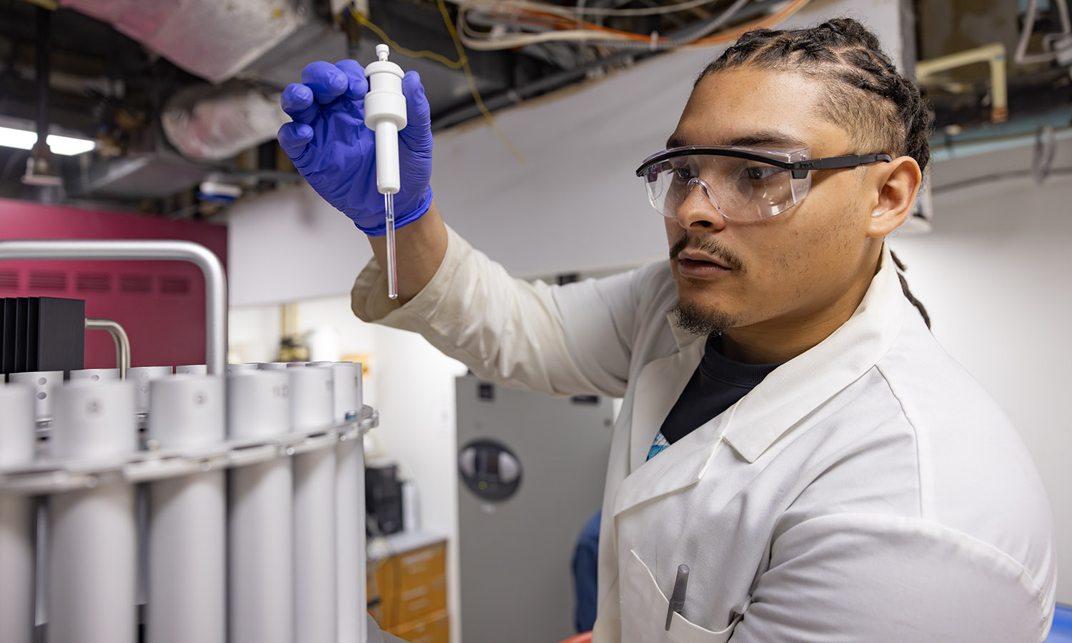 As part of an independent study in chemistry aimed at discovering new anticancer compounds, Ameer Muse ’26 inserts the first-ever sample into the carousel of a new 500 MHz nuclear magnetic resonance (NMR) spectrometer. The purchase of the NMR was made possible by HWS Trustee Kevin Stein ’88. 