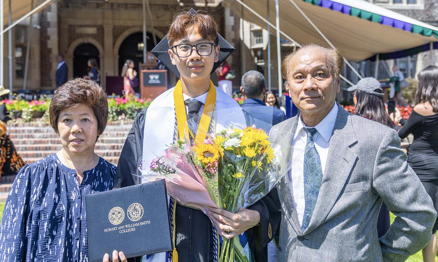 Randy Hong ’26 poses with his parents after delivering a commencement senior speech written in their honor. He said about his father: “This accomplishment — graduating college — is one that I share with him.” 
