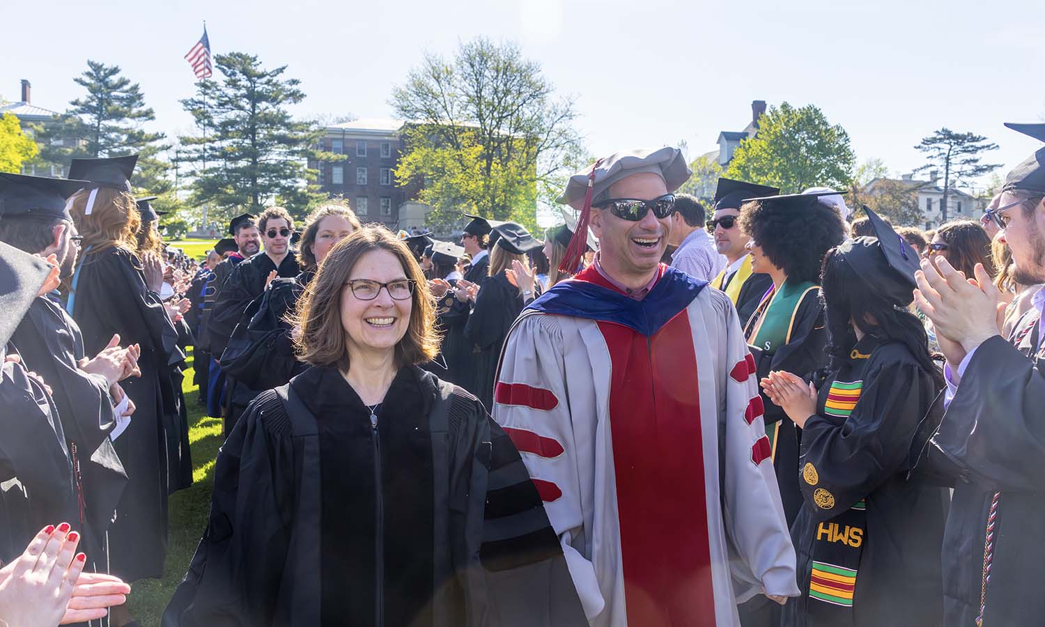 Associate Professor of Environmental Studies Beth Kinne and Professor of Chemistry Justin Miller process while students applaud. 