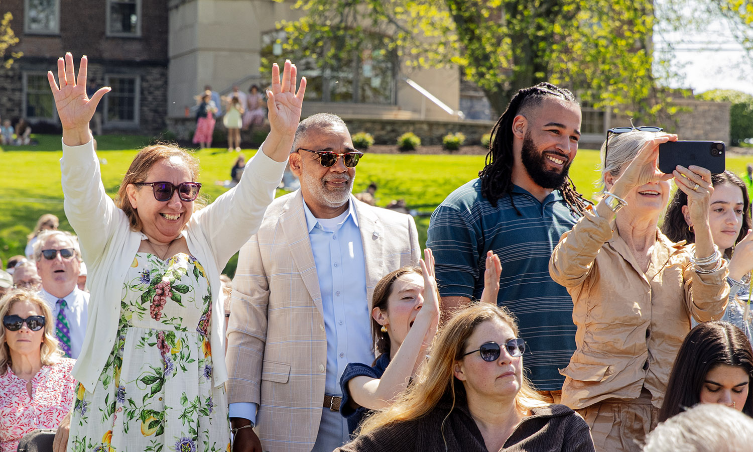 Family members celebrate as their student walks across the graduation stage. 
