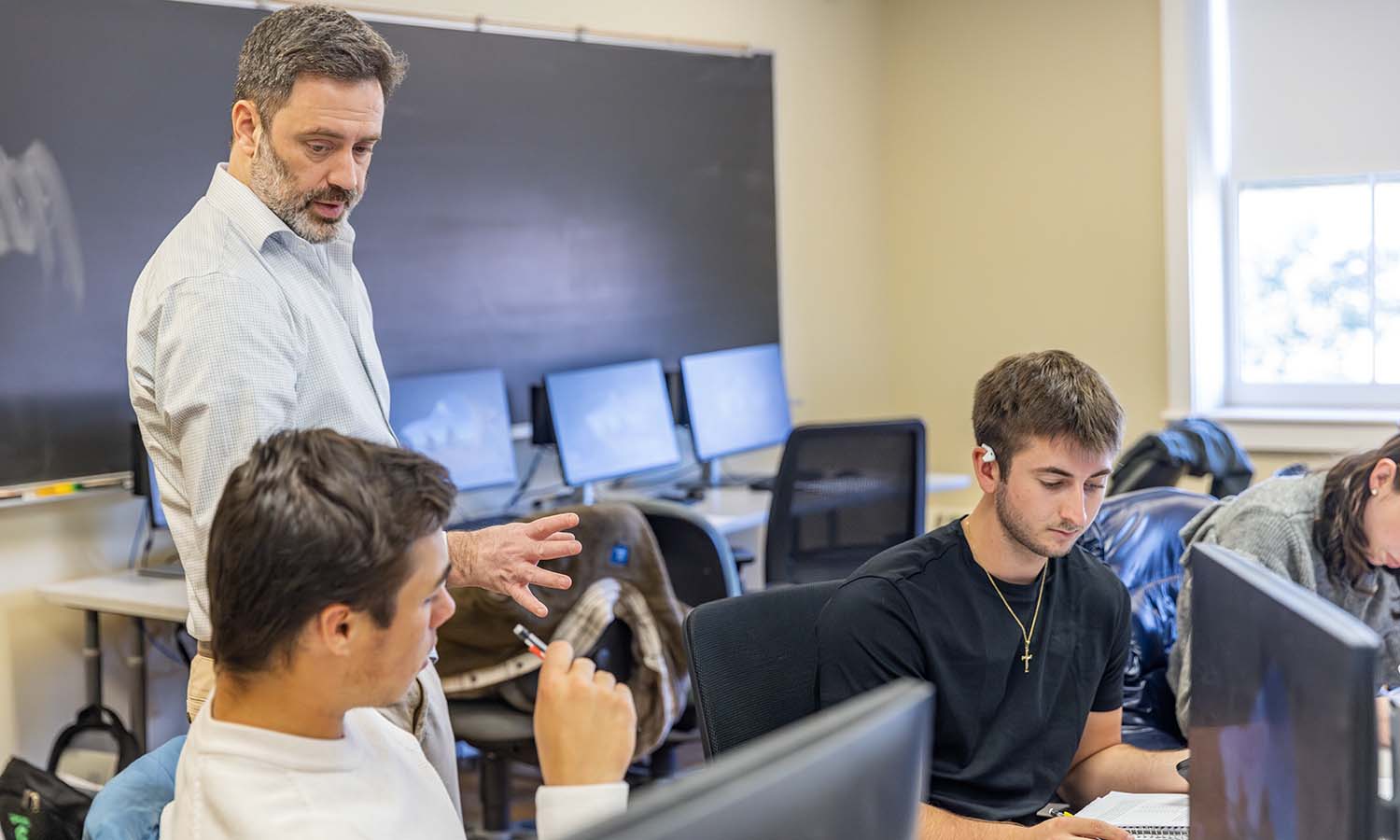 Associate Professor of Economics Joshua Greenstein assists students with an in-class problem set in "Statistics." 