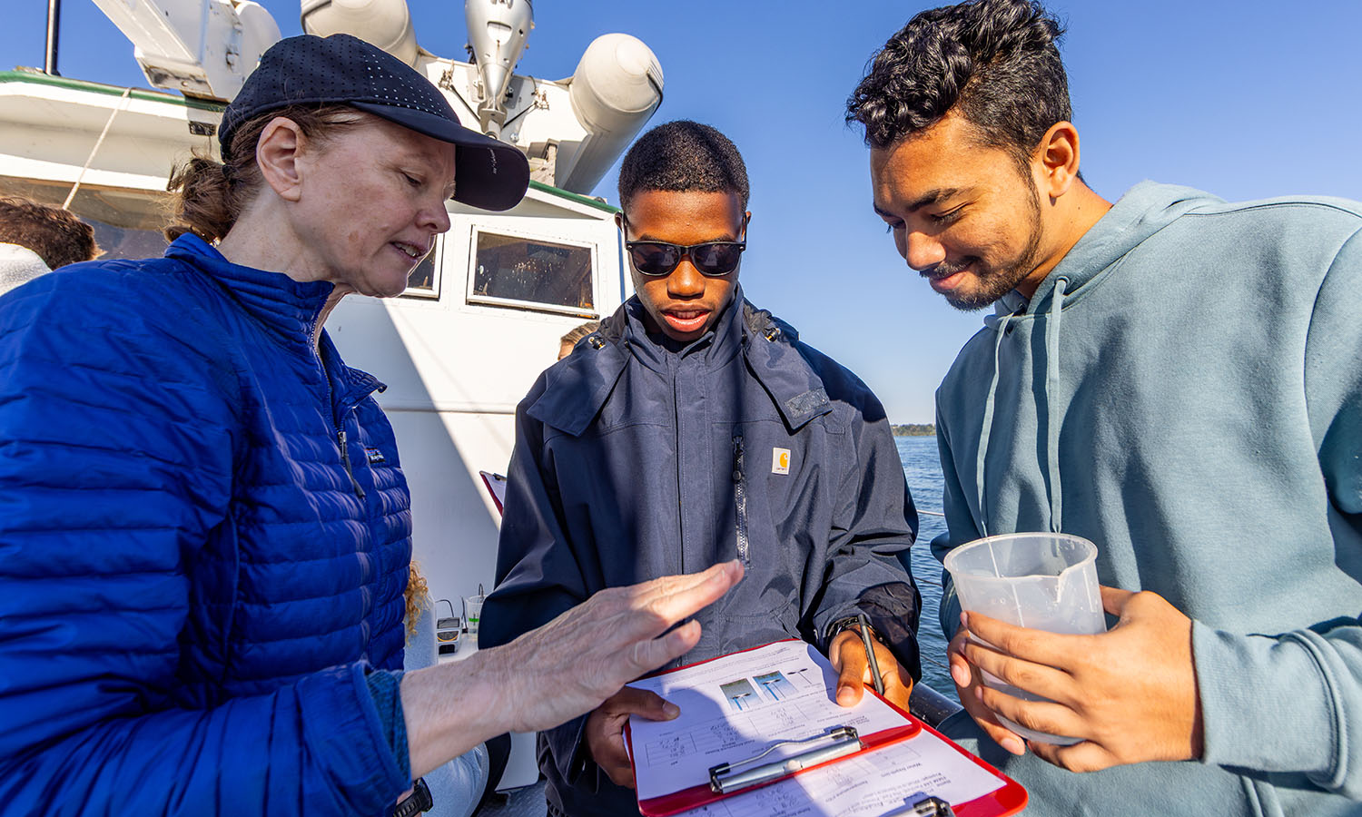 While aboard the William Scandling Research Vessel during “Parched” with Associate Professor of Geoscience Tara Curtin, Jubayer Ansary ’29 and Nigel Presume ’29 discuss the pH and total dissolved solids in water sampled from Seneca Lake. 