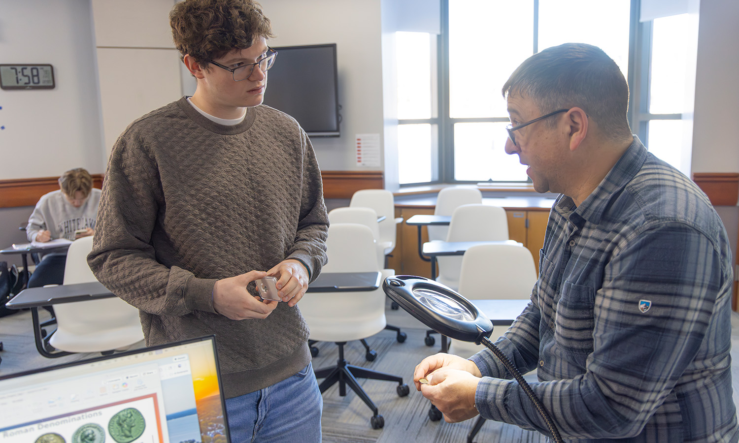 Christian Kneaskern '28 examines an ancient coin with Associate Professor of Greek and Roman Studies Jim Capreedy in "Ancient Epigraphy." 