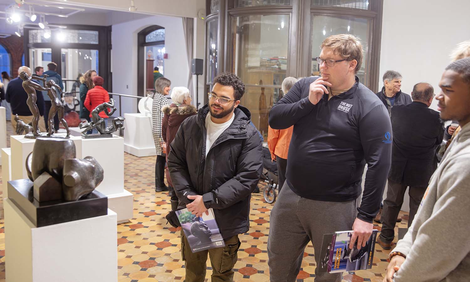 Students appreciate the artwork at the opening of “Upside-Down and Backwards: A Retrospective Exhibition Celebrating the Work of Professor Emeritus A. E. Ted Aub” in the Davis Gallery at Houghton House. 