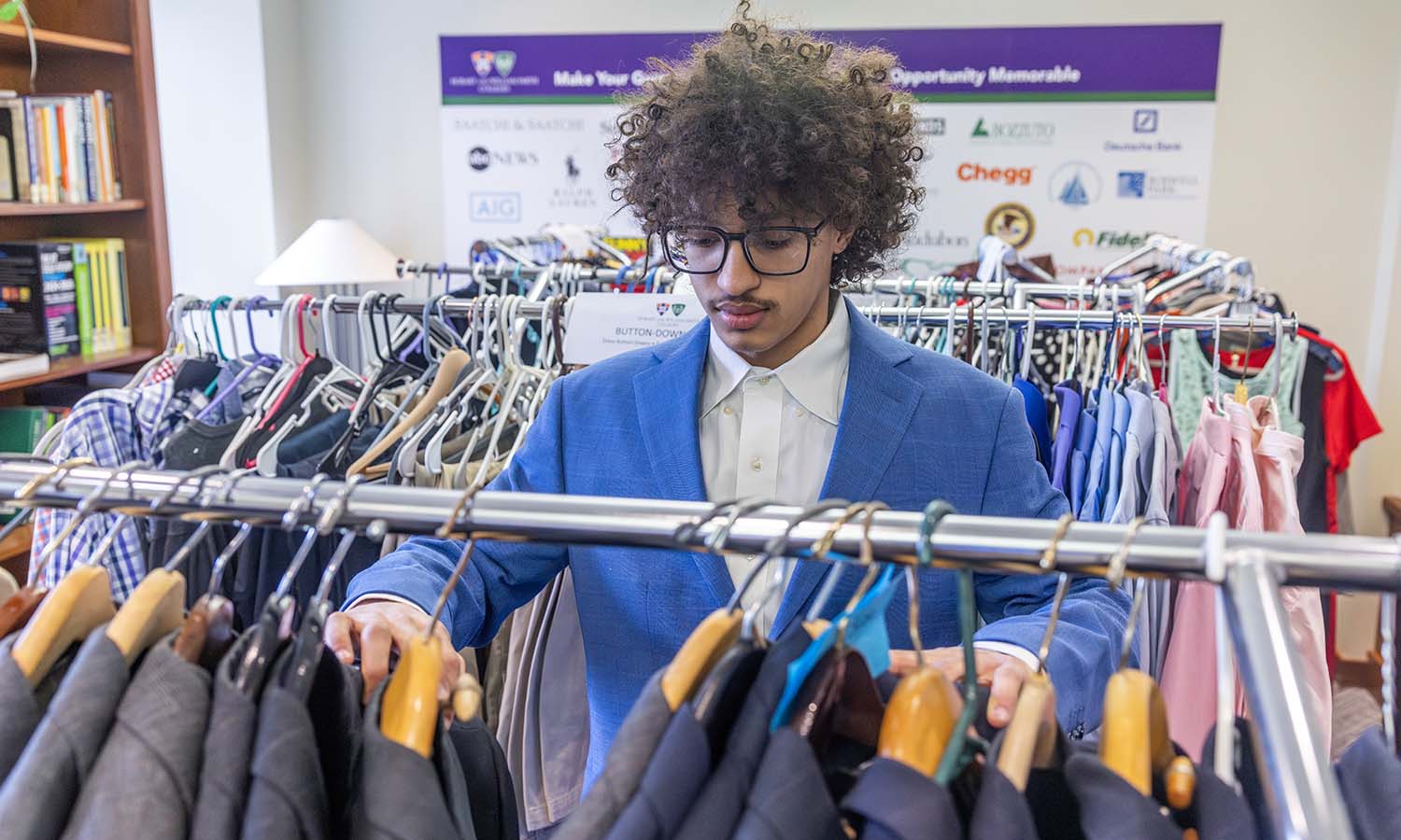 Devyn Williams ’28 sorts through free, professional clothing in the Salisbury Center’s Career Closet in Trinity Hall. 