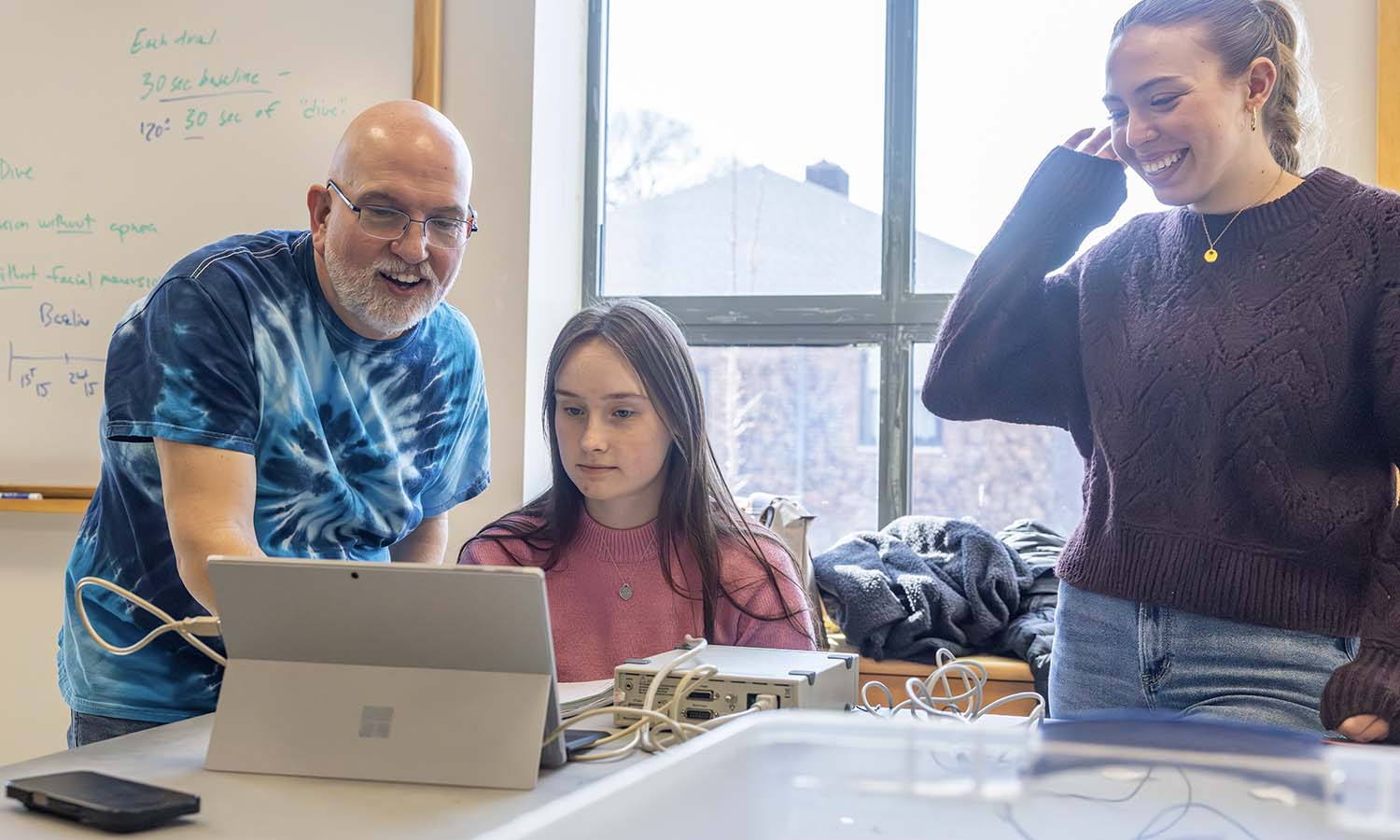 Professor of Biology Mark Deutschlander helps Paige Madison ’26 and Jaylynn McCarthy ’26 with a lab activity during “General Physiology.” 