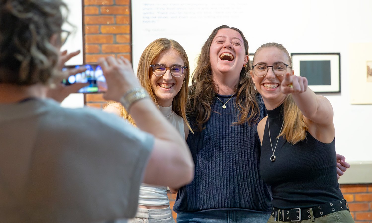 Students pose for a photo in the Solarium Gallery during a reception for "(De)Constructing Absence: Photography and the Myth of the Vanishing Indian’ curated by Tayla Peters ’26.  