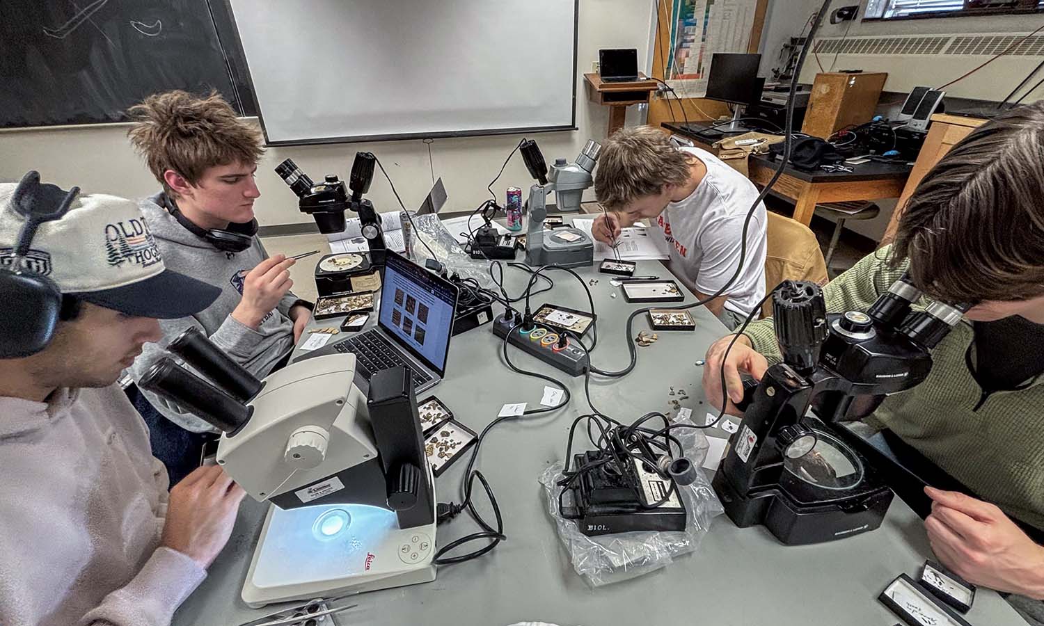 Students in “Paleontology” with Associate Professor of Geoscience David Kendrick examine fossils under microscopes. 