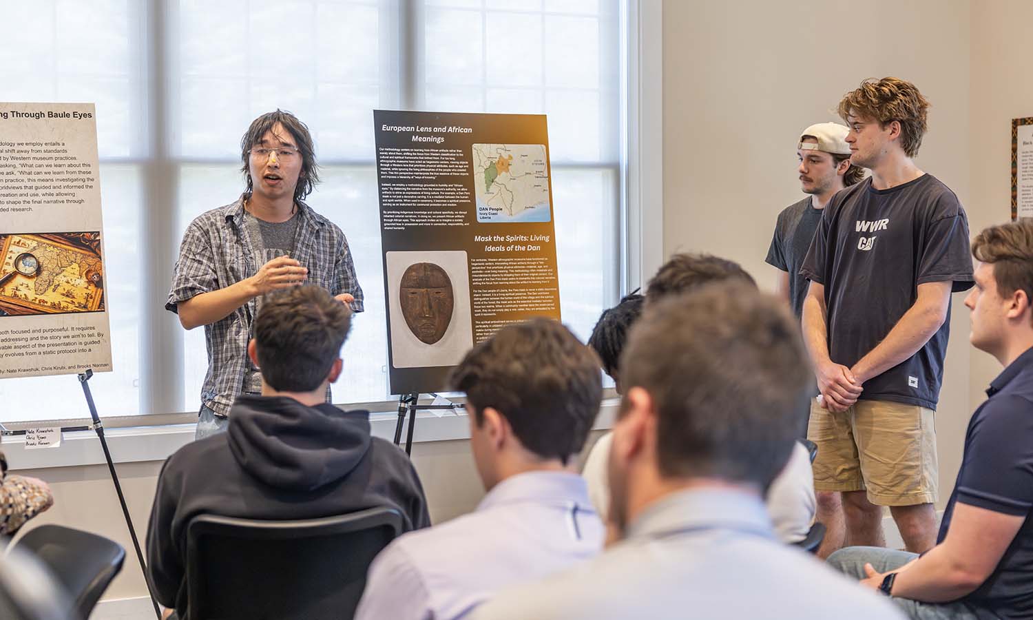 Isaak Uriu ‘28, Steven Pickering ‘26 and Tag Walker ‘28 give a final presentation in the Stine Room of the Adams Intercultural Center during “Reclaiming African Artifacts” with Assistant Professor of History Virgil Slade. 