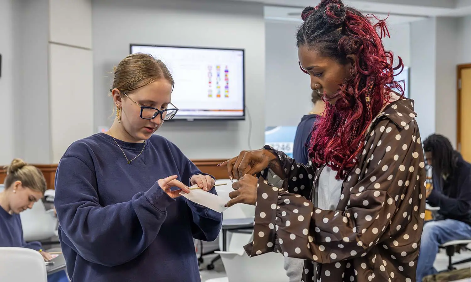 Visiting Assistant Professor of Africana Studies Coraline Kandassamy assists a student with creating a French flag during "Introduction to French." 