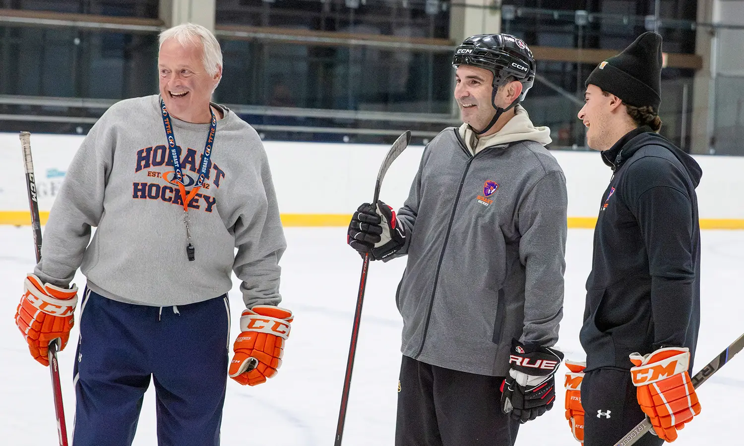 Retired FDNY firefighter and 9/11 first responder Rob Serra '01 (center) shares a laugh with Thomas B. Poole '61 and Family Head Coach of Hobart Hockey Mark Taylor and Hockey Operations Assistant Victor Cutting '28 during a recent practice.  