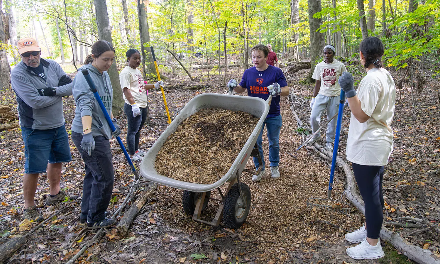 Aspen McAuley '29, Heliana Rivers '30, Chas Doerflinger '27, Henniyah Rivers '30, and Sophia Pomposello '27 help spread mulch to maintain Loomis Woods Park walking trails during HWS Day of Service. 