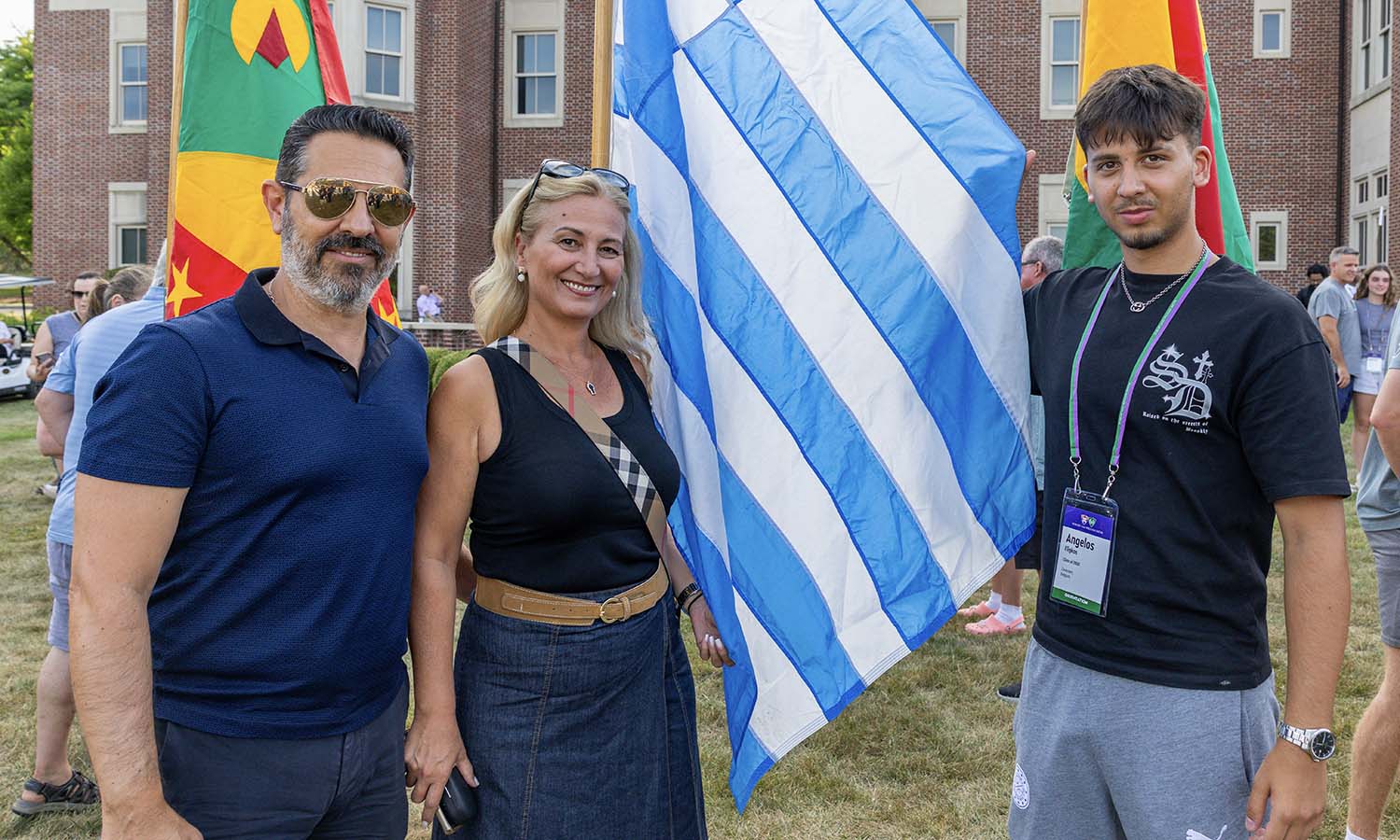 Joined by family, Angelos Fligkos ’30 of Zaventem, Belgium poses with the Greece flag. 