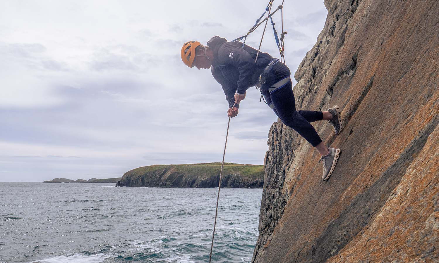 Sean Garvin ’27 participates climbs down a rock face onto the beach in Pembrokeshire. Photo by Nekorrah Raynor. 