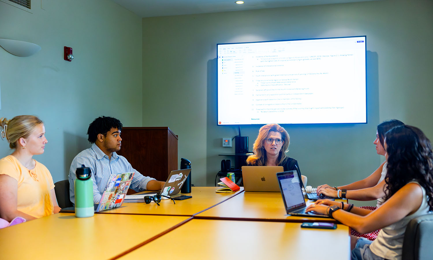 Ellie Teerlink ’28, Hilton Johnson '29, Samantha Edwards '28 and Salma Menkari ’27 work with Professor of International Relations Stacey Philbrick Yadav to explore the relationship between international law, forced migration and refugee policy.  