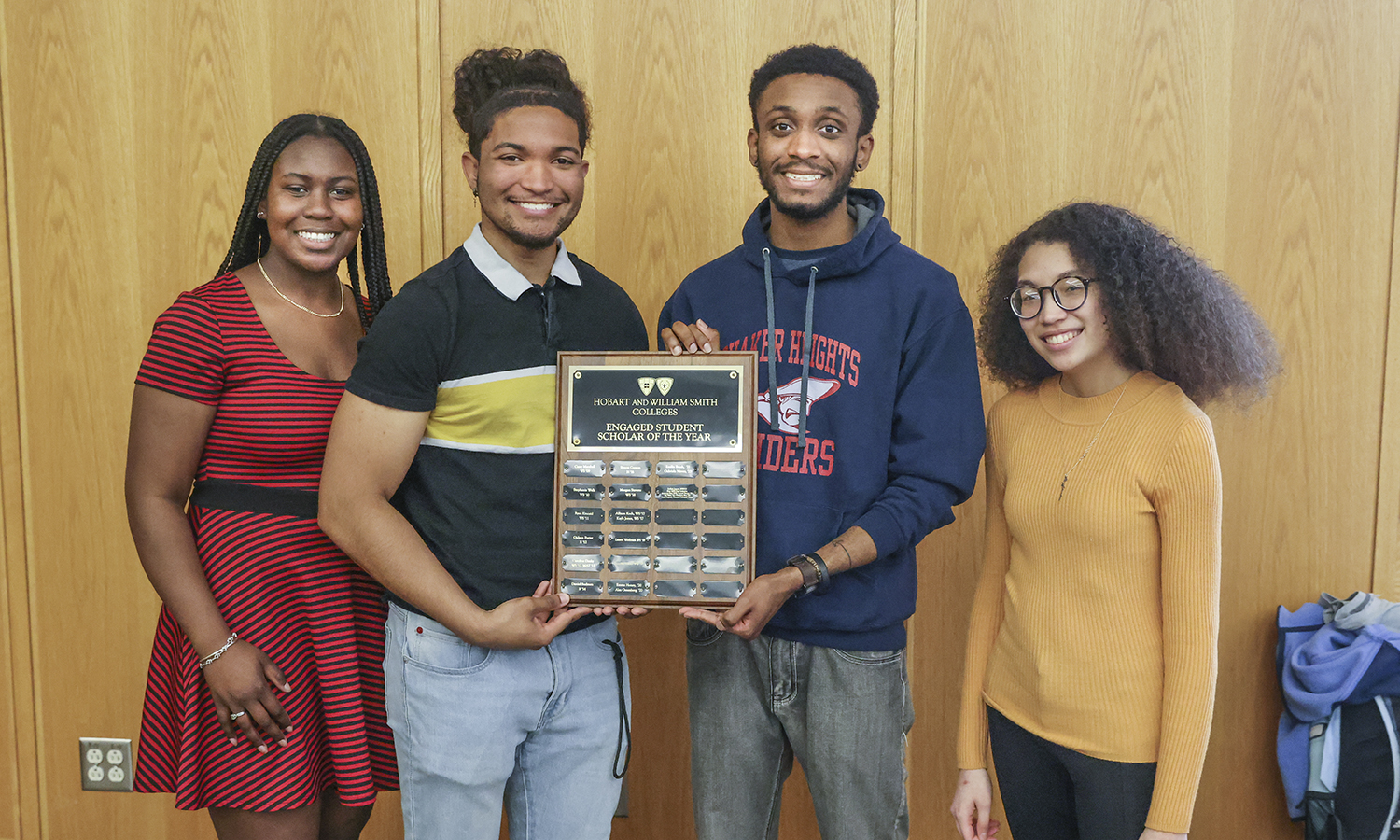 Students hold community awards plaque