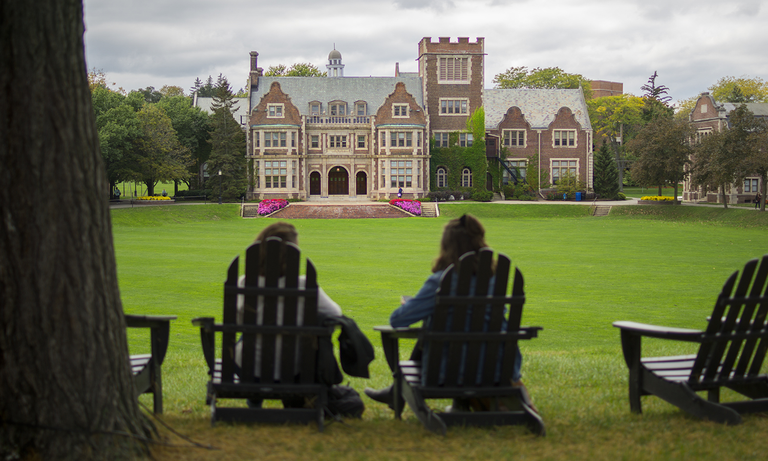Students sit in Adirondack chairs, overlooking the Quad