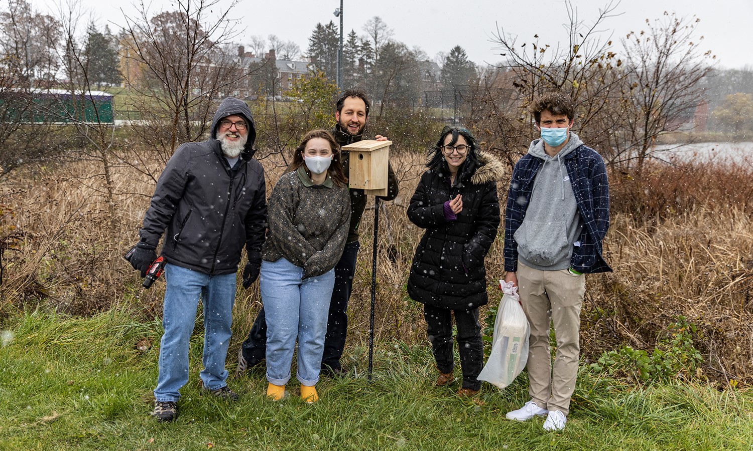 Members of the birding club gather for a photo in the snow